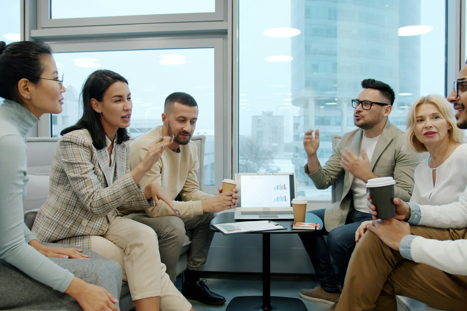 A multilingual team talking together in a modern office