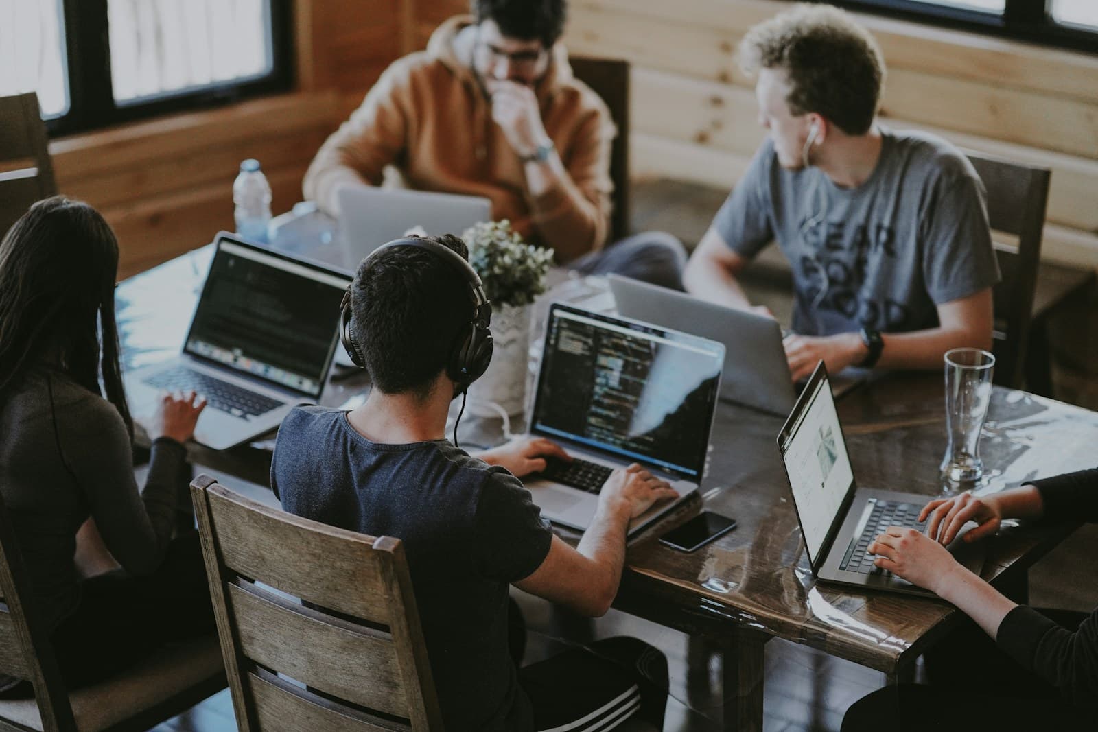 A team working together around laptops in a shared workspace